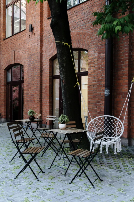 a hammock hanging from a tree in a courtyard, by Vadym Meller, temporary art, cafe tables, in legnica, profile image, hammershøi