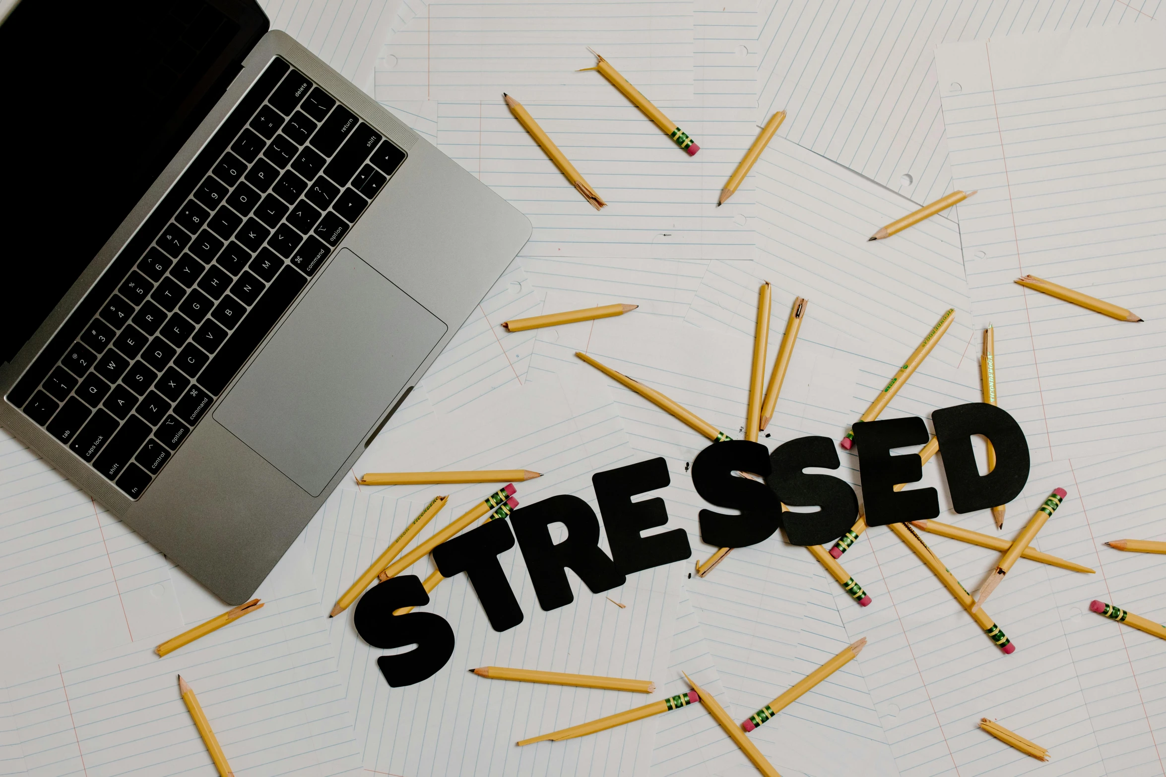 a laptop computer sitting on top of a pile of pencils, a picture, trending on pexels, process art, stressed expression, sitting cross-legged, ptsd, movie still of a tired