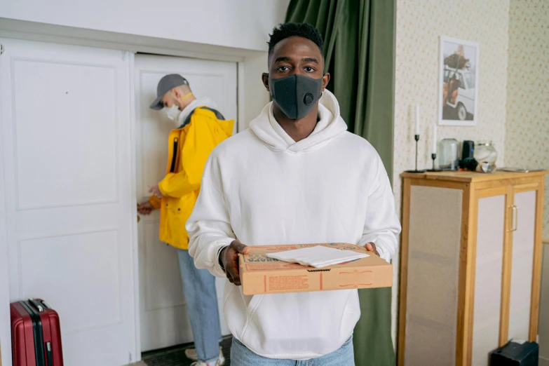 a man wearing a face mask holding a box of pizza, a photo, arbeitsrat für kunst, jaylen brown, felix englund, about to enter doorframe, high quality upload