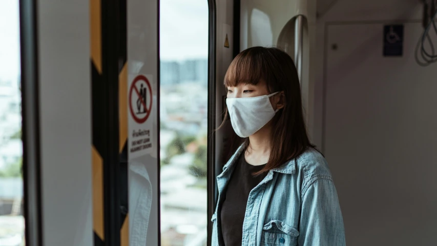 a woman wearing a face mask on a train, trending on pexels, avatar image, yun ling, grey, portrait image