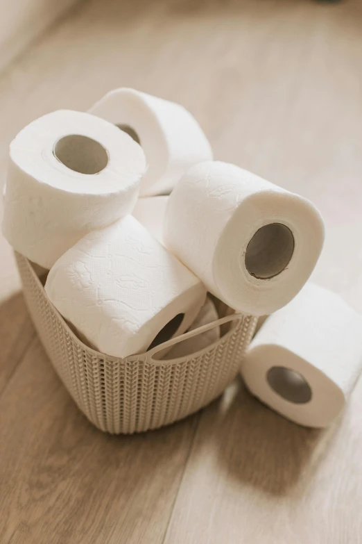 several rolls of toilet paper in a basket on the floor, inspired by Sarah Lucas, unsplash, porcelain organic tissue, 6 pack, 王琛, petite