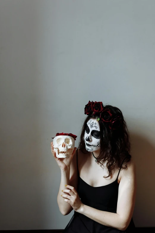 a woman in day of the dead makeup holding a skull, by Lucia Peka, pexels contest winner, vanitas, minimal black skull warpaint, cup of death, low quality photo, ilustration