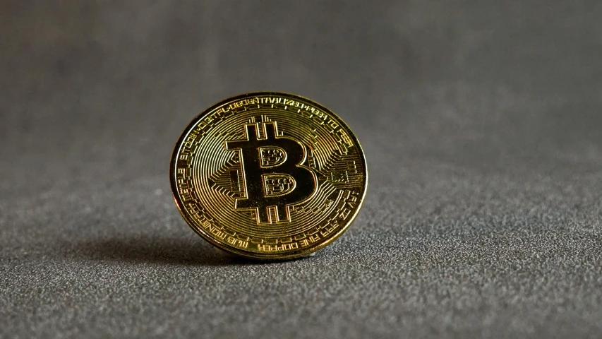 a bit coin sitting on top of a table, screensaver, product image, on a gray background, no watermarks