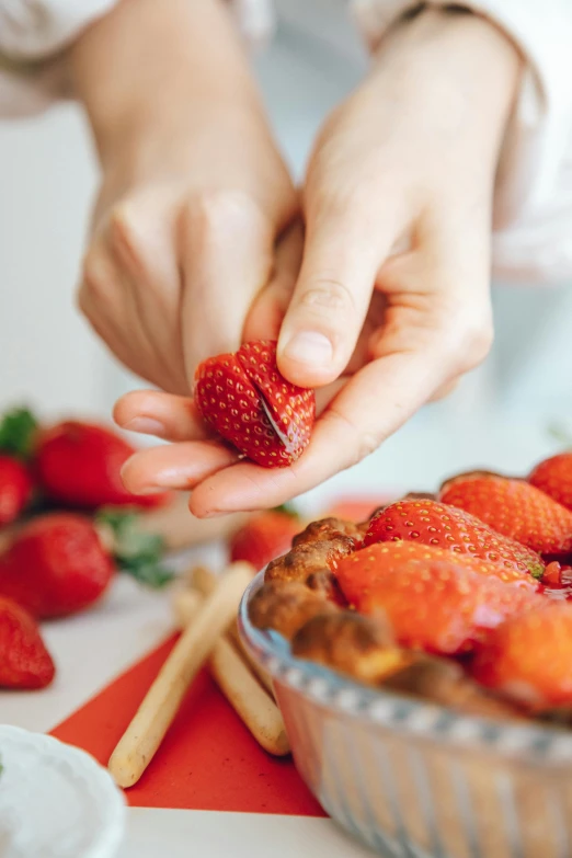 a close up of a person holding a strawberry, cooking, offering a plate of food, sweets, straining