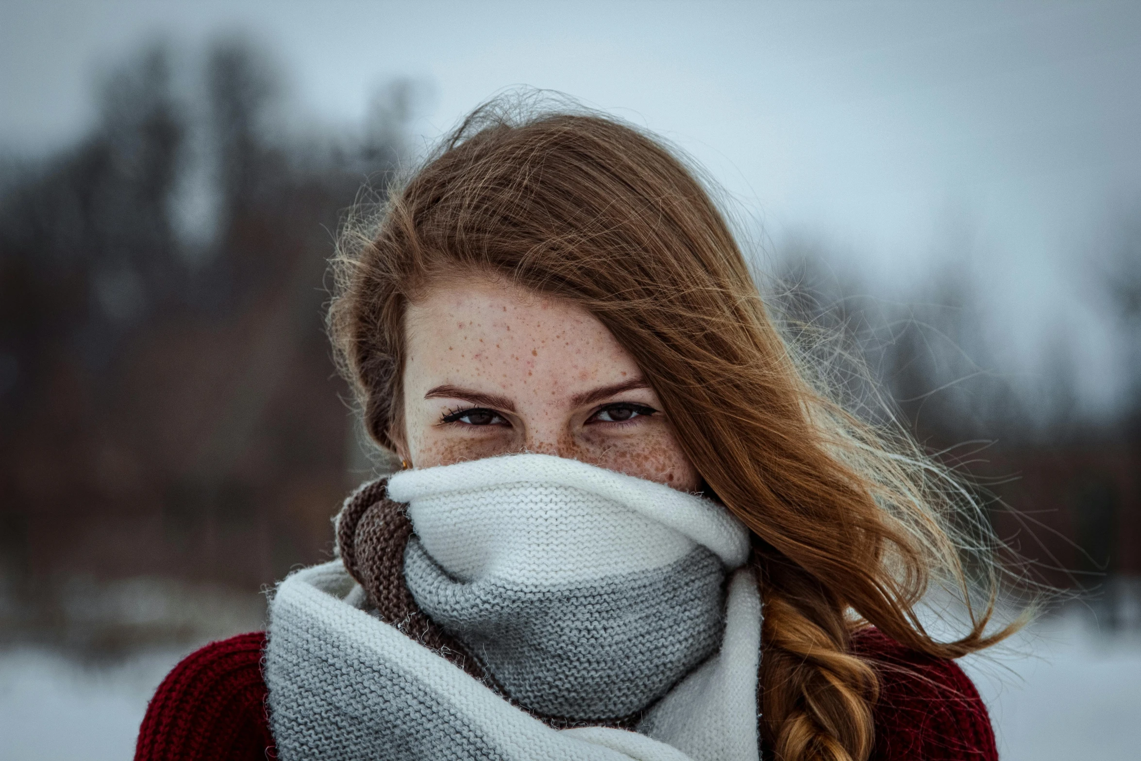 a woman covering her face with a scarf, by Adam Marczyński, trending on pexels, renaissance, cute young redhead girl, frozen cold stare, wearing a sweater, white freckles