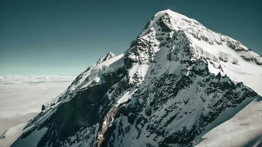 a man standing on top of a snow covered mountain, pexels contest winner, “ aerial view of a mountain, high resolution ultradetailed, swiss alps, with snow on its peak