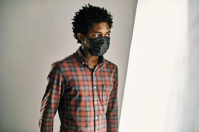 a man wearing a face mask standing in front of a window, black man with afro hair, in a photo studio, illustration »