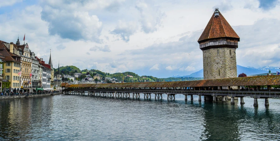 a bridge over a body of water with buildings in the background, by Julia Pishtar, pexels contest winner, renaissance, swiss, thatched roofs, stepping on towers, hd footage