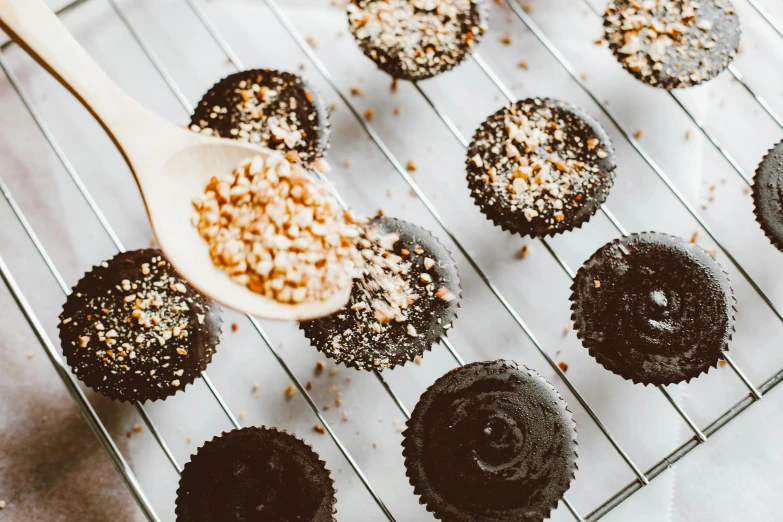 a close up of chocolate cupcakes on a cooling rack, by Julia Pishtar, trending on pexels, hurufiyya, sexy sesame seed buns, drooling ferrofluid, thumbnail, unfinished