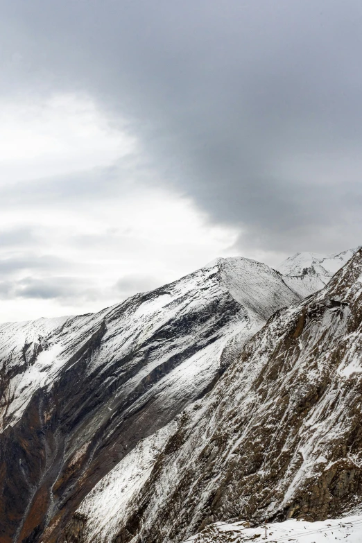 a man standing on top of a snow covered mountain, les nabis, today\'s featured photograph 4k, overcast skies, nepal, 4 k cinematic panoramic view