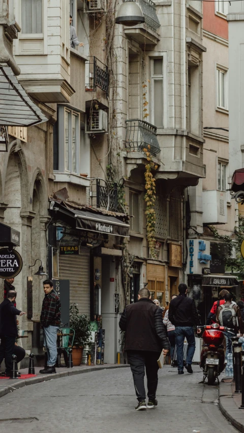 a group of people walking down a street next to tall buildings, by Cafer Bater, pexels, art nouveau, istanbul, shop front, banner, thumbnail