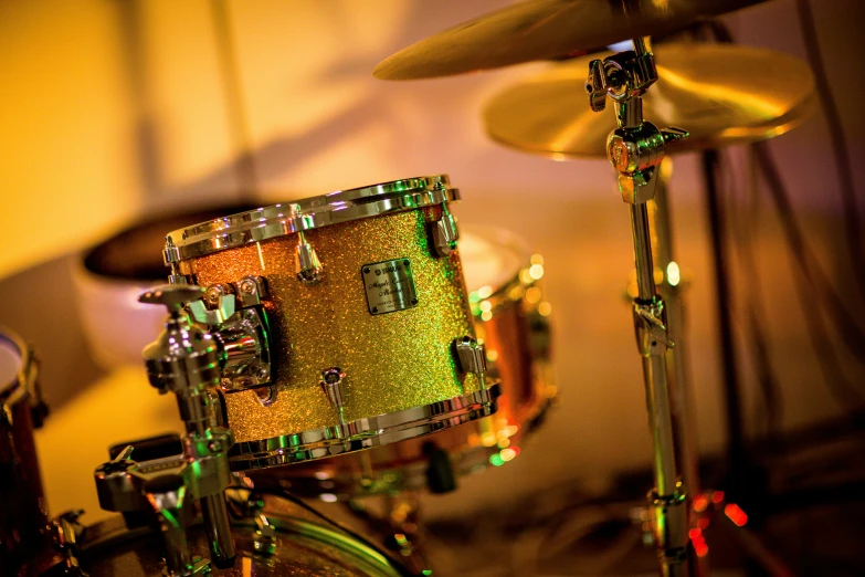 a close up of a drum set in a room, by Julia Pishtar, glitter, lime and gold hue, profile image, performing