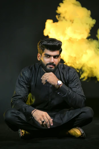 a man sitting in front of a cloud of yellow smoke, an album cover, by Max Dauthendey, pexels contest winner, a portrait of rahul kohli, badass pose, thick black smoke and fire, sittin