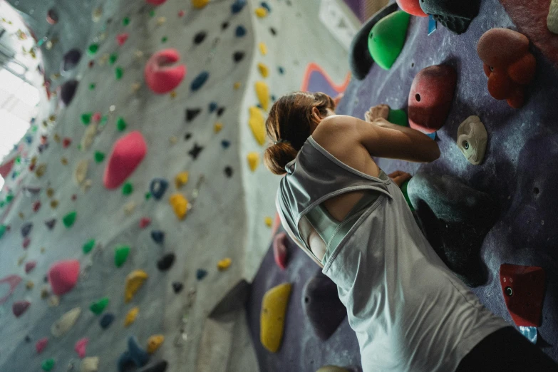 a woman standing in front of a climbing wall, pexels contest winner, manuka, head down, local gym, 🦩🪐🐞👩🏻🦳