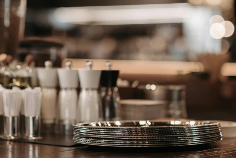 a close up of a plate on a table, unsplash, stainless steel, the last supper, at the counter, curated collections