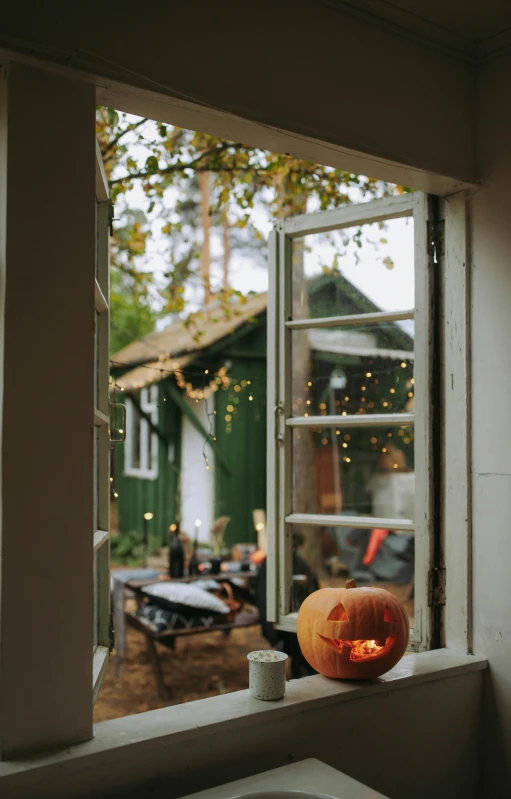 a pumpkin sitting on top of a window sill, by Jessie Algie, pexels, small cottage in the foreground, festive atmosphere, doorway, gif