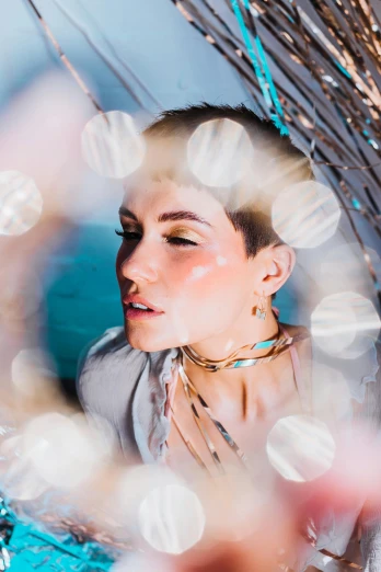 a woman that is standing in front of a mirror, an album cover, bokeh iridescent accents, pixie cut with shaved side hair, elaborate oled jewelry, kailee mandel