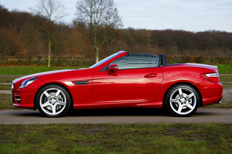 a red sports car parked on the side of the road, pexels contest winner, romanticism, soft top roof raised, right side profile, slr, no cropping