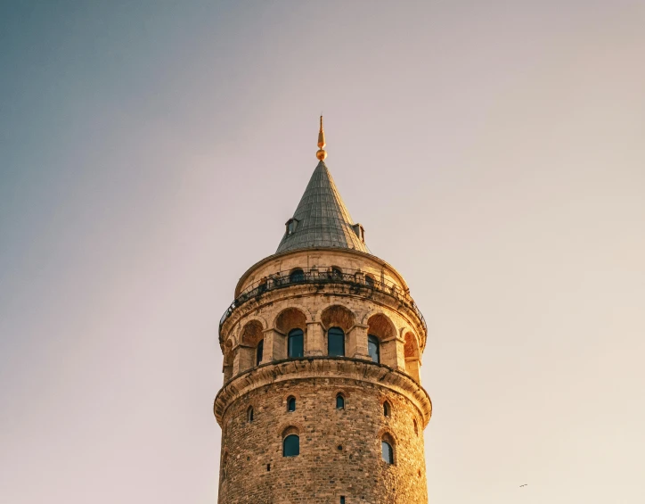 a tall tower with a clock on top of it, trending on pexels, hurufiyya, turkey, warm light, cone shaped, 256x256