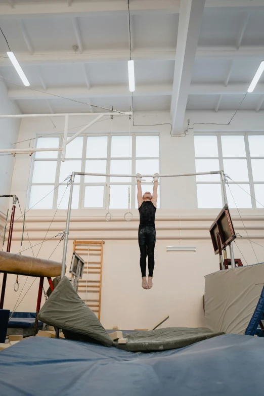 a person on a balance beam in a gym, by Emanuel Witz, arabesque, wide overhead shot, anna nikonova aka newmilky, birch, mechanics