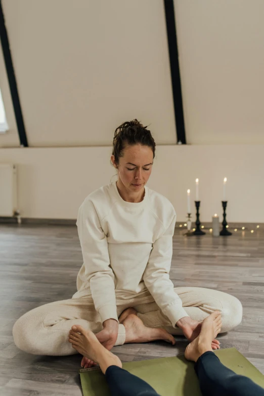 a woman sitting on a yoga mat in a room, a picture, by Jan Tengnagel, low quality photo, natural candle lighting, gif, sweat