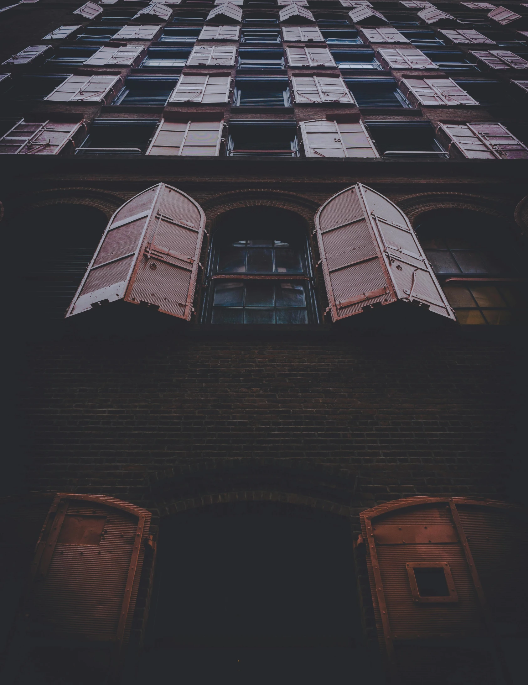 a tall building with lots of windows and shutters, inspired by Elsa Bleda, unsplash contest winner, very dark and abandoned, vintage photo, instagram photo, in an alley