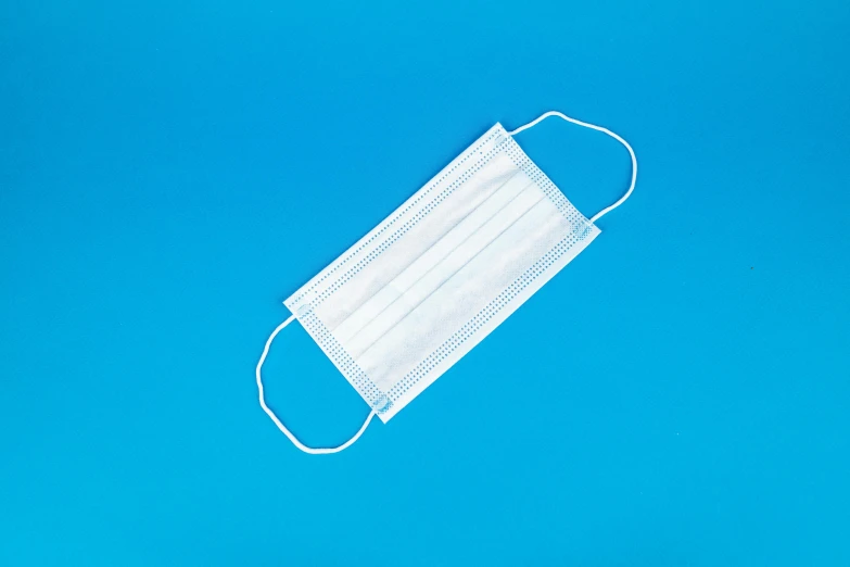 a medical mask on a blue background, product photograph, 4 0 0 0 0 0, rectangular, flat