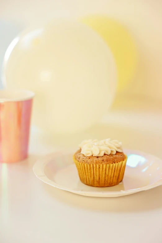 a cupcake sitting on top of a white plate, balloon, paper cup, white pearlescent, full product shot