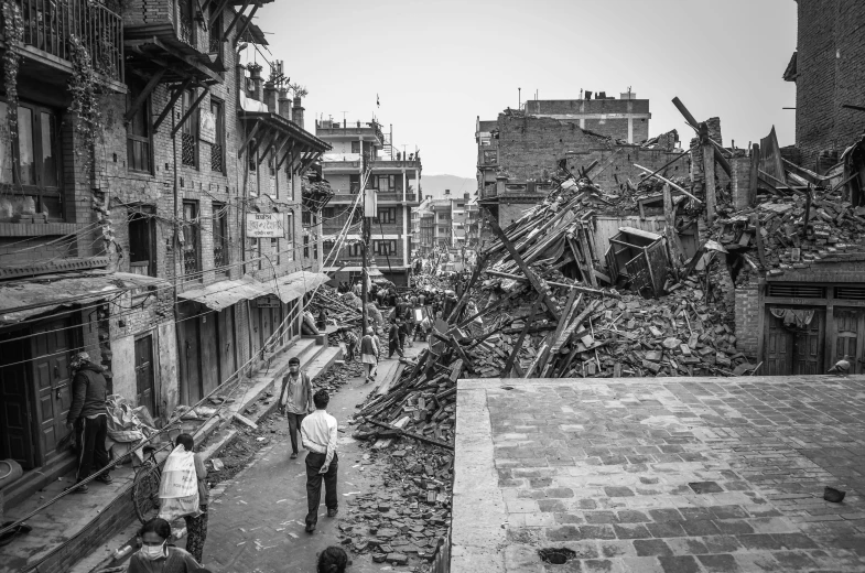 a couple of men walking down a street next to a pile of rubble, a black and white photo, pexels contest winner, nepali architecture buildings, buildings collapsed, a quaint, an intricate