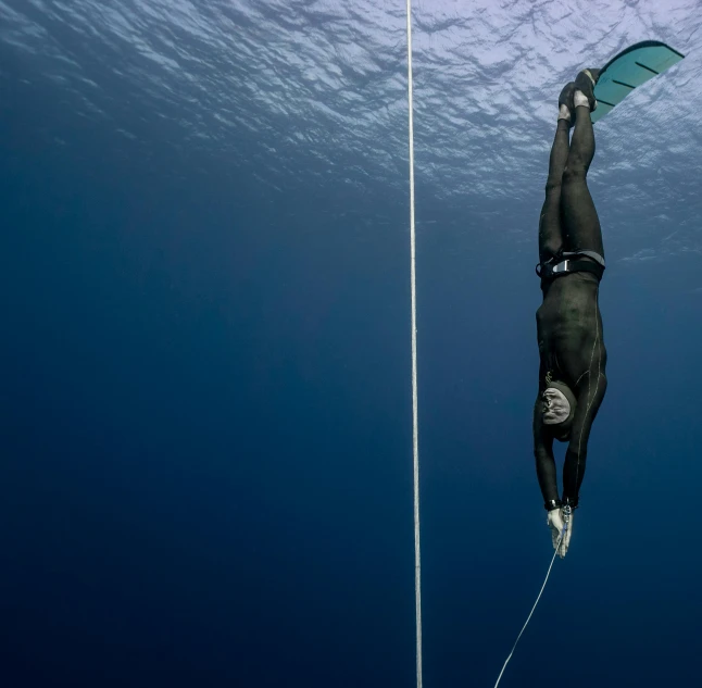 a man that is in the water with a surfboard, by Alison Watt, unsplash contest winner, figuration libre, hanging rope, under blue, scuba diving, hans bellmer and nadav kander