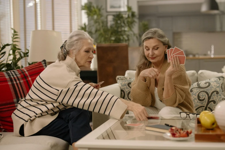 two women sitting on a couch playing cards, pexels contest winner, going gray, thumbnail, 15081959 21121991 01012000 4k, medium head to shoulder shot