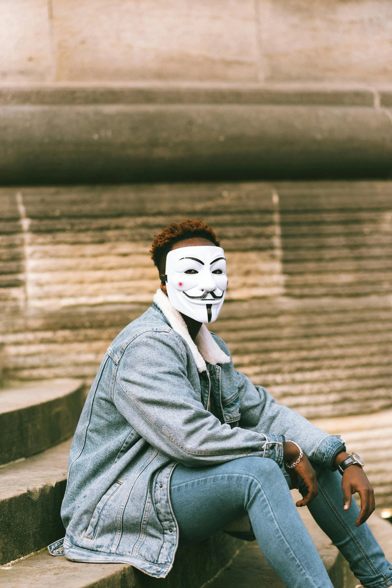 a person wearing a mask sitting on some steps, trending on pexels, antipodeans, androgynous face, domino mask, 15081959 21121991 01012000 4k, wearing bandit mask