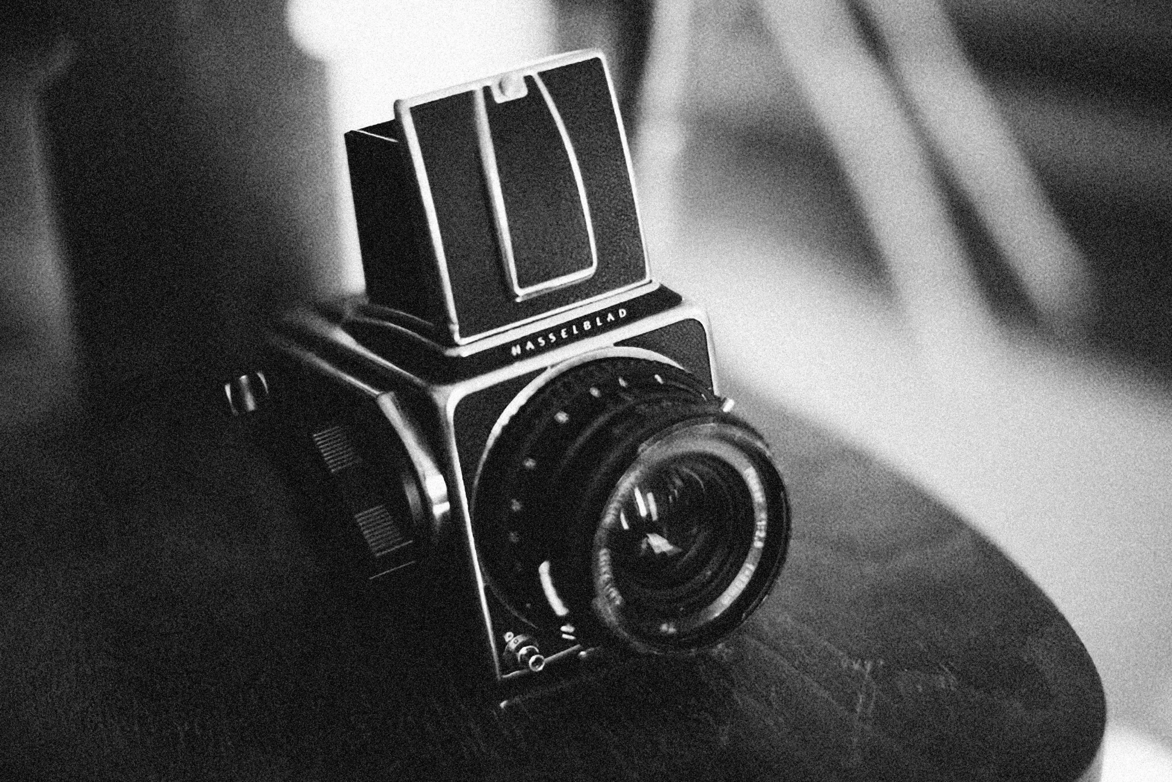 a black and white photo of a camera on a table, photorealism, 24mm hasselblot photography, vintage soft grainy, rolleiflex, 1966