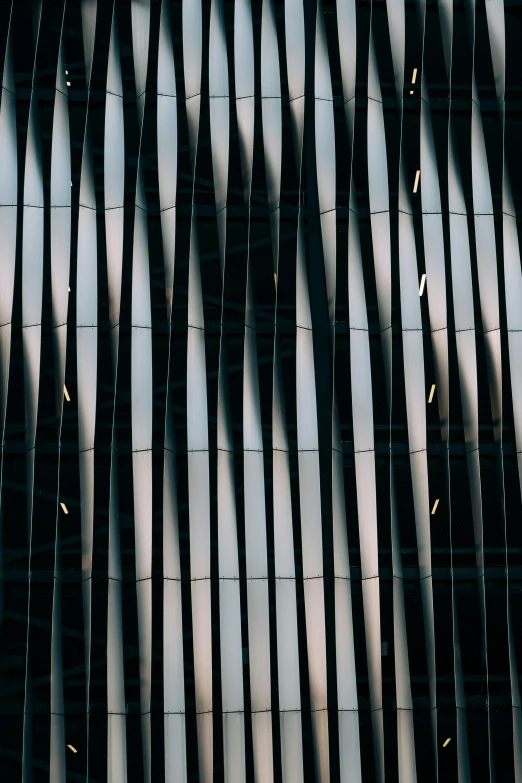 a group of people standing in front of a tall building, pexels contest winner, modernism, black stripes, glass texture, folds, evening lights