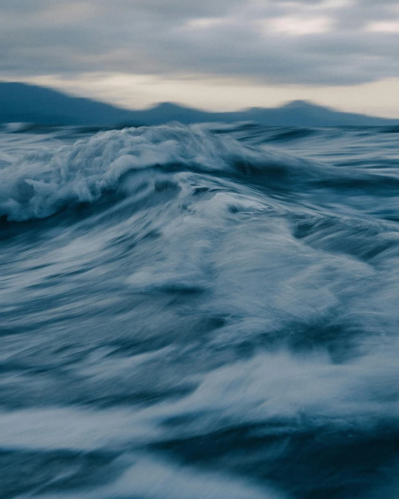 a large body of water under a cloudy sky, an album cover, unsplash contest winner, romanticism, turbulent waves, thumbnail, multiple stories, running water