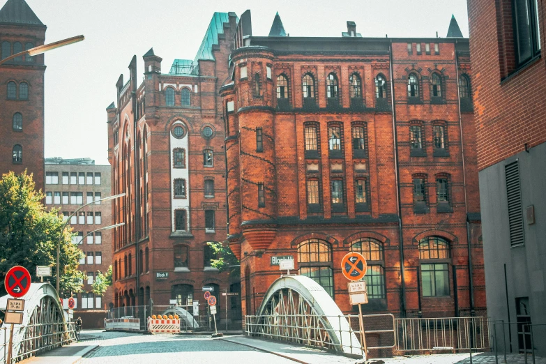 a red brick building sitting on the side of a road, inspired by Thomas Häfner, pexels contest winner, art nouveau, big arches in the back, manchester, berlin city, mill