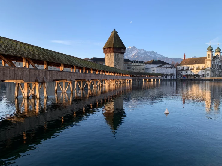 a wooden bridge over a body of water, by Karl Stauffer-Bern, pexels contest winner, renaissance, brutalist buildings tower over, brittney lee, 256x256, olafur eliasson