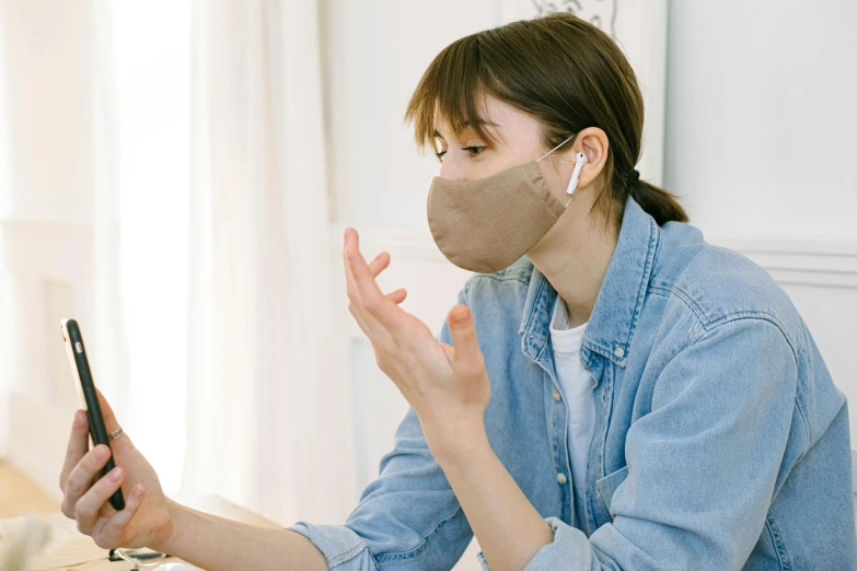 a woman sitting at a table using a cell phone, dust mask, beige, avatar image, kantoku