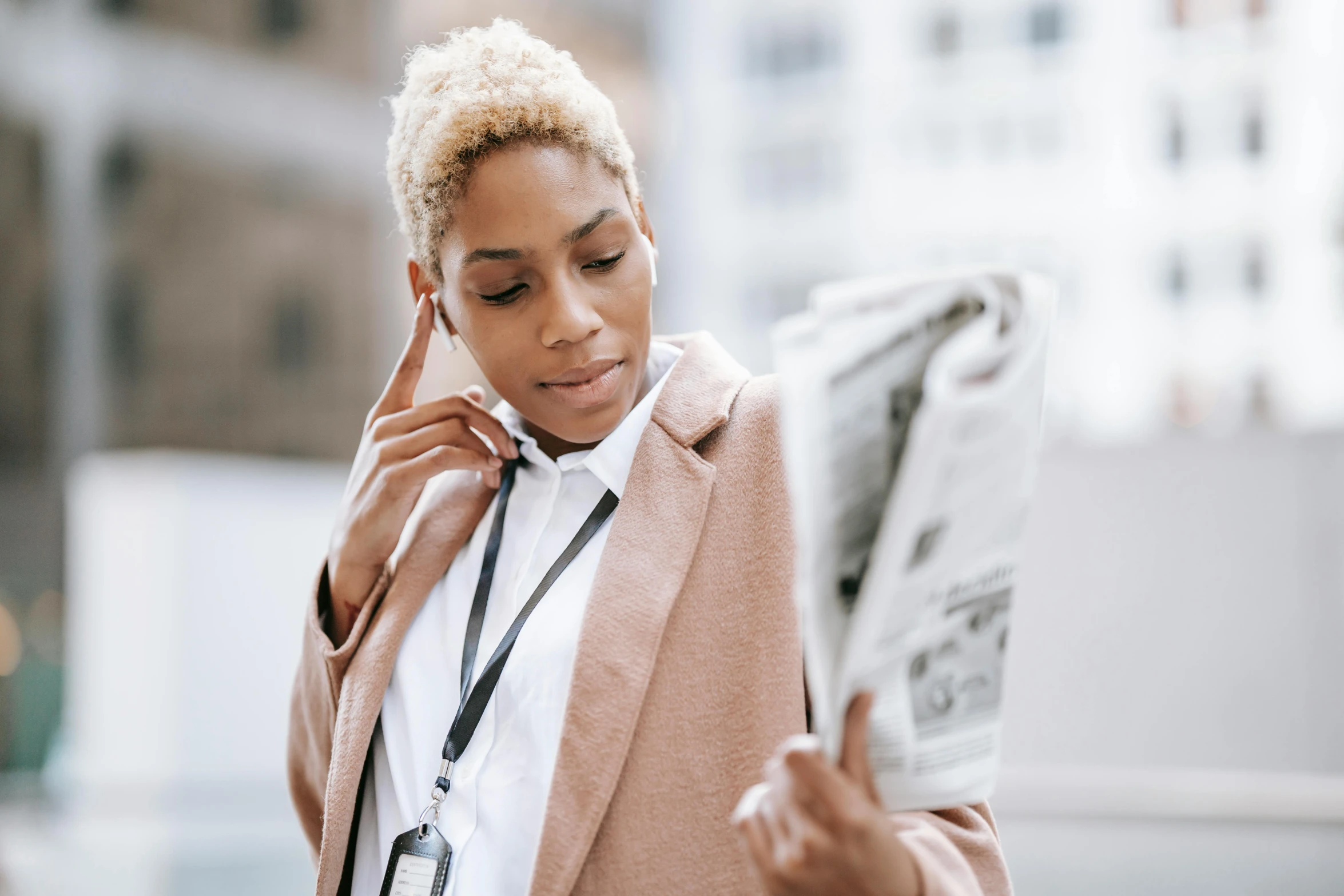 a woman talking on a cell phone while holding a newspaper, trending on pexels, private press, short blonde afro, woman is in a trenchcoat, topknot, professional picture