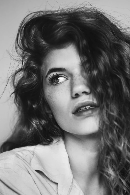 a black and white photo of a woman with long hair, inspired by irakli nadar, tumblr, photorealism, ginger wavy hair, cynthwave, wide lips and kind blue eyes, messy curly hair