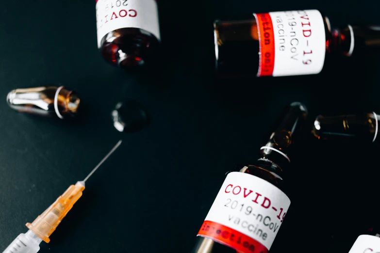 a bunch of medicine bottles sitting on top of a table, by Julia Pishtar, trending on pexels, lyco art, black and red scheme, holding a syringe, poster of corona virus, 3 - piece