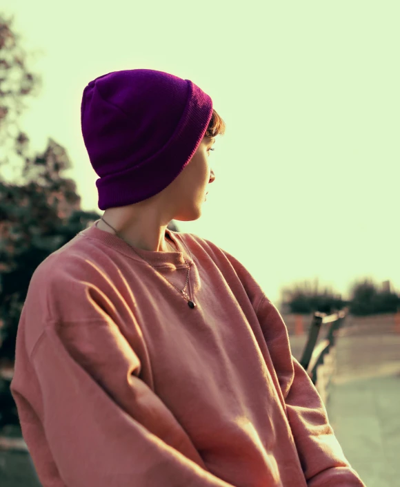 a person sitting on a bench with a skateboard, an album cover, inspired by Seb McKinnon, trending on pexels, happening, beanie hat, second colours - purple, profile shot, early morning light