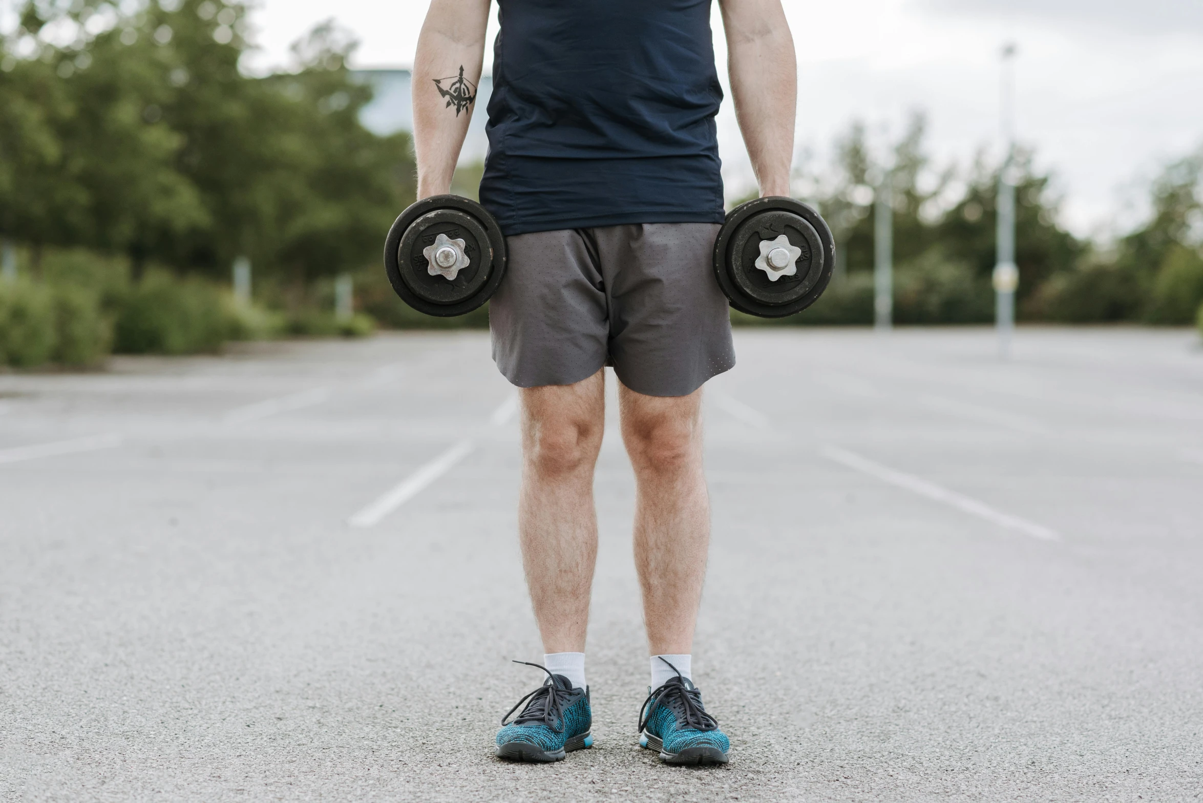 a man holding two dumbbells in a parking lot, pexels contest winner, round thighs, profile image, thumbnail, background image