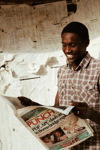 a man reading a newspaper on a bed, brown skin man with a giant grin, somalia, studying in a brightly lit room, mechanics