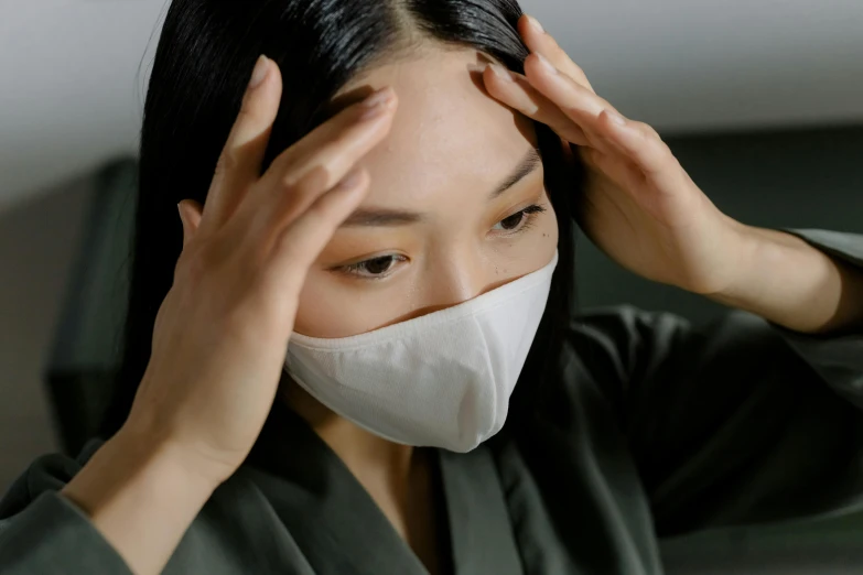 a woman with a face mask covering her face, trending on pexels, mingei, left hand propping up the head, nurse, shy looking down, thumbnail