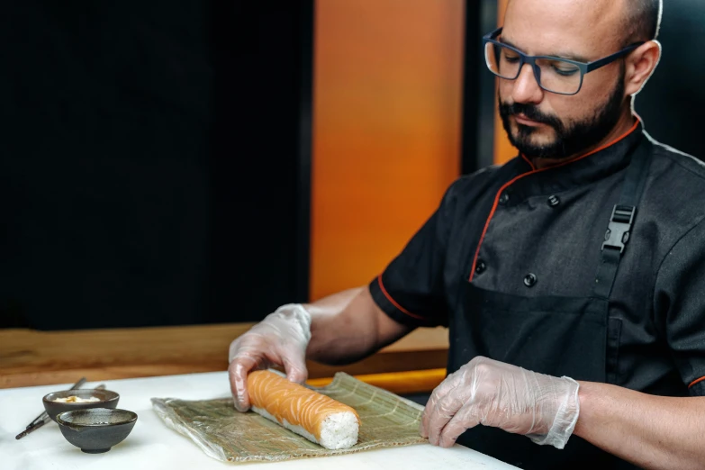 a man in a chef's uniform preparing food on a cutting board, inspired by Géza Dósa, salmon khoshroo, resin, thumbnail, in the shape of a cinnamon roll