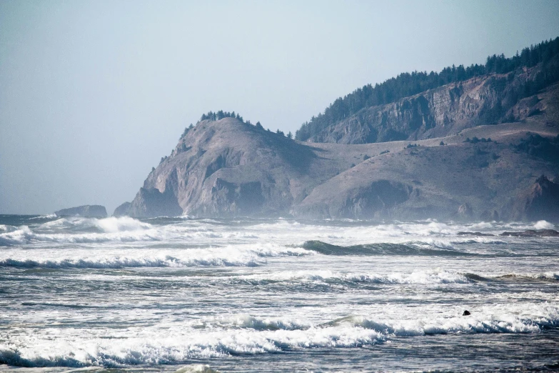 a man riding a surfboard on top of a wave covered beach, by Jessie Algie, pexels contest winner, detailed trees and cliffs, oregon, ghost giant above the horizon, thumbnail