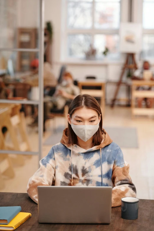 a woman sitting at a table with a laptop wearing a face mask, trending on pexels, renaissance, tie-dye, young asian woman, photo of a classroom, 15081959 21121991 01012000 4k