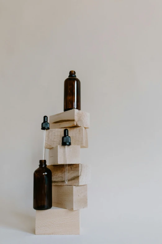 a stack of bottles sitting on top of a wooden block, unsplash, visual art, skincare, dwell, profile picture, brown