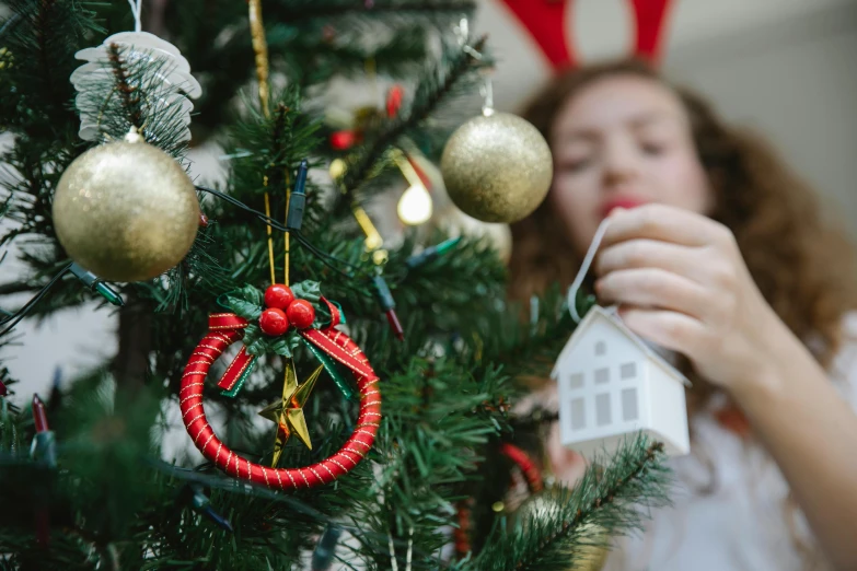 a woman decorating a christmas tree with ornaments, by Julia Pishtar, pexels contest winner, teaser, avatar image, teenage girl, handmade